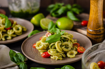 Homemade pasta with fresh basil pesto and tomatoes