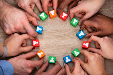 People's Hand Holding Colorful Wooden Block With People Icon