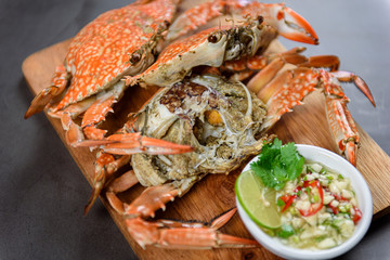 Steamed blue crab on wooden plate with spicy seafood sauce, Thai Food