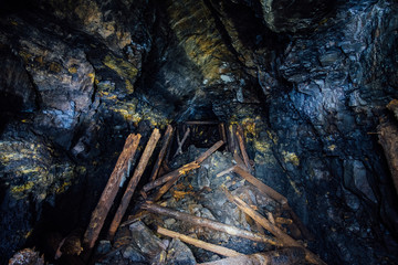 Abandoned coal mine with rotten collapsed wooden miner stands. Old derelict coal development