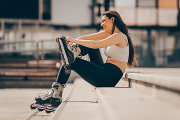 Teenager on rollerblading sitting on street a sunny day. active lifestyle