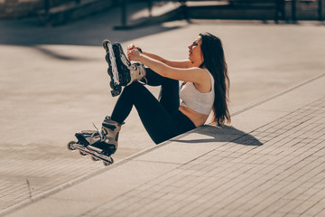 Girl sitting on stairs and puts on skates
