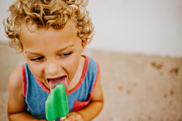 Little boy eating frozen popsicle