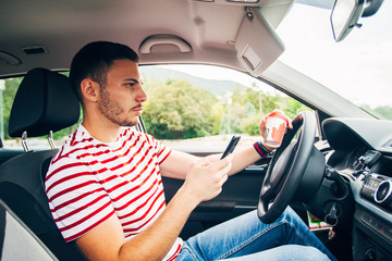 Naklejka premium Guy in a car with coffee and phone