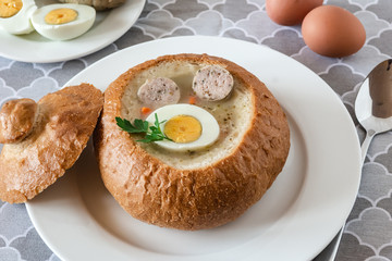 The sour soup (zurek) made of rye flour with sausage and egg served in bread bowl. Popular Easter dish.