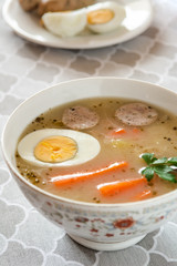 Traditional Polish soup Zurek with white sausage and egg.