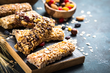 Granola bar with nuts, fruit and berries on black.