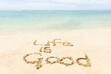 Fototapeta na wymiar Life Is Good Text Written On The Sand At Beach