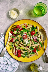 Penne pasta with vegetables : green pea, grilled bell pepper, tomato and zucchini. Top view with copy space.
