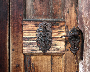 details of an old church wooden door:   bronze handles and keyhole