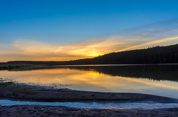 Beautiful sunset over the lake in the countryside in summer.