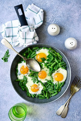 Healthy vegetarian breakfast : fried eggs and asparagus bean in a skillet.Top view.