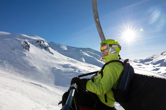 Oldeer woman sitting in a ski lift on sunny day