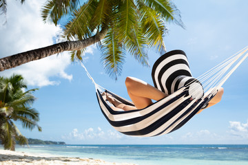 Woman Relaxing On Hammock At Beach