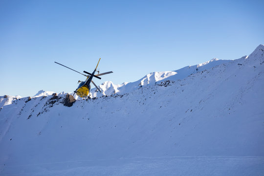 Helicopter flying over snow-covered mountain