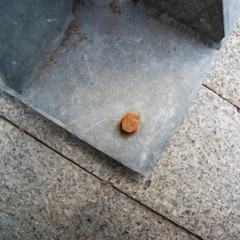 Square background with corrosion on the bolt holding the heavy metal column