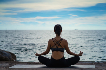 Portrait of young woman practicing yoga at the sea.Relax at the sea.Meditation