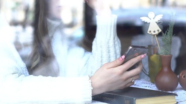 Cute Girl Working In A Cafe For A Laptop Communicates In A Chat. Frame Through