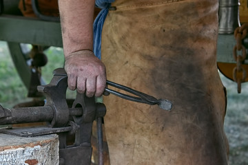 Male hands of a blacksmith with coal dust on the skin and mites on the background of a stained...