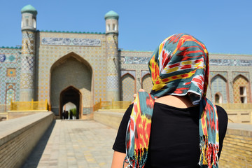 Fototapeta na wymiar Tourist admiring the Khudayar Khan Palace, the most popular landmarks of Fergana Valley, Kokand, Uzbekistan, Silk Route