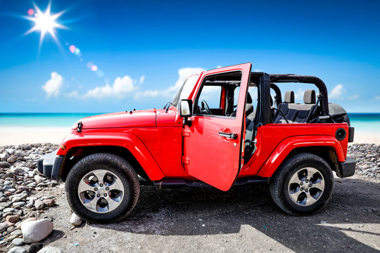 Red big sumer car with suitcase on beach and ocean landscape. Free space for your decoration and sunny day. 