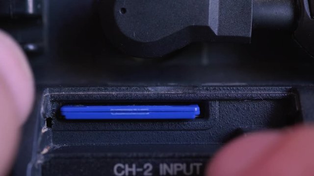 Changing SD card on professional video camera. 4k video macro shot