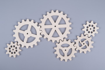 Gears assembled in a puzzle mechanism to work on a gray background. Business concept idea,...