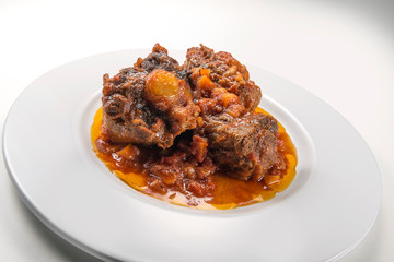 Isolated Dish with a portion of oxtail stewed vaccinara