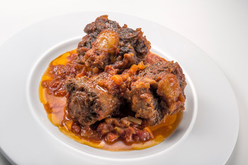 Isolated Dish with a portion of oxtail stewed vaccinara