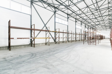 Interior of empty warehouse with empty racks.