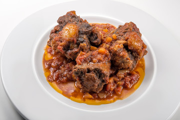 Isolated Dish with a portion of oxtail stewed vaccinara