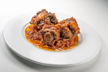 Isolated Dish with a portion of oxtail stewed vaccinara
