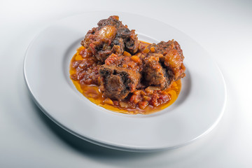 Isolated Dish with a portion of oxtail stewed vaccinara