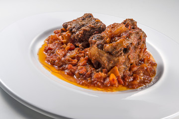 Isolated Dish with a portion of oxtail stewed vaccinara