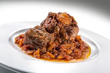 Isolated Dish with a portion of oxtail stewed vaccinara