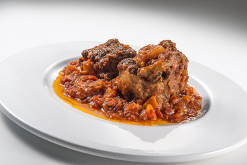 Isolated Dish with a portion of oxtail stewed vaccinara