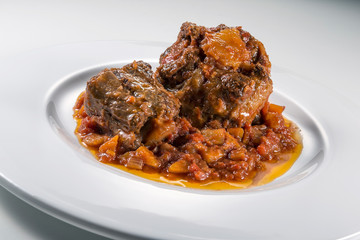 Isolated Dish with a portion of oxtail stewed vaccinara