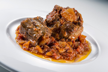Isolated Dish with a portion of oxtail stewed vaccinara