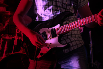 Plakat Life style image of close up young male guitarist hand, playing electric guitar