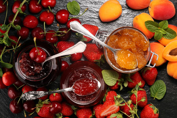 assortment of jams, seasonal berries, apricot, mint and fruits. marmalade or confiture