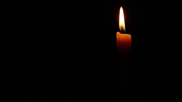 Simple burning candle on a black background. full-HD 1920 X 1080