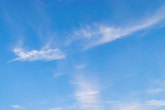Beautiful skyscape with white cirrus clouds against a bright blue sky.