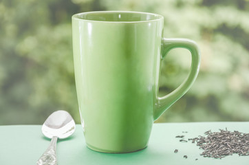 green cup of tea on a beautiful green background. Tinted.