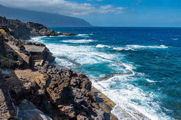 Acantilado con mar de fondo y zonas de baño
