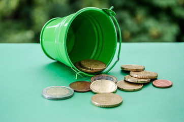 coins in a green bucket on a green background