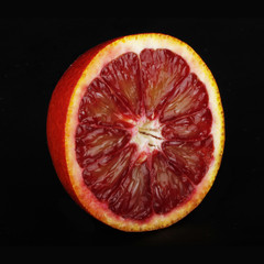 half of bloody red orange isolated on black background