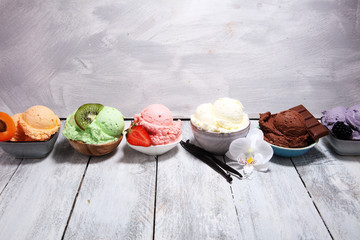 ice cream scoops of different colors and flavours with berries, nuts and fruits decoration on white background