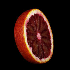 slice of bloody red orange isolated on black background