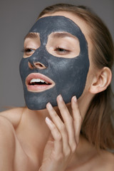 Skin care. Woman face with cosmetic spa clay mask closeup