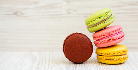 Sweet and colorful macarons on a white wooden background, side view. Copy space.